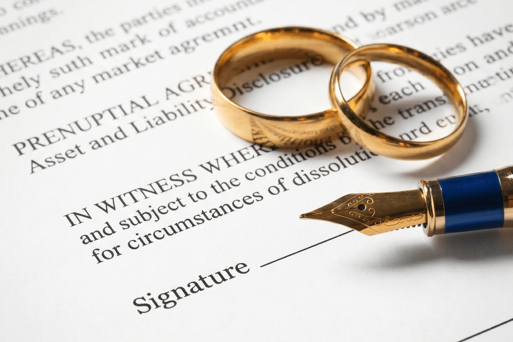 Two gold wedding bands rested on torn divorce paperwork, symbolizing separation.